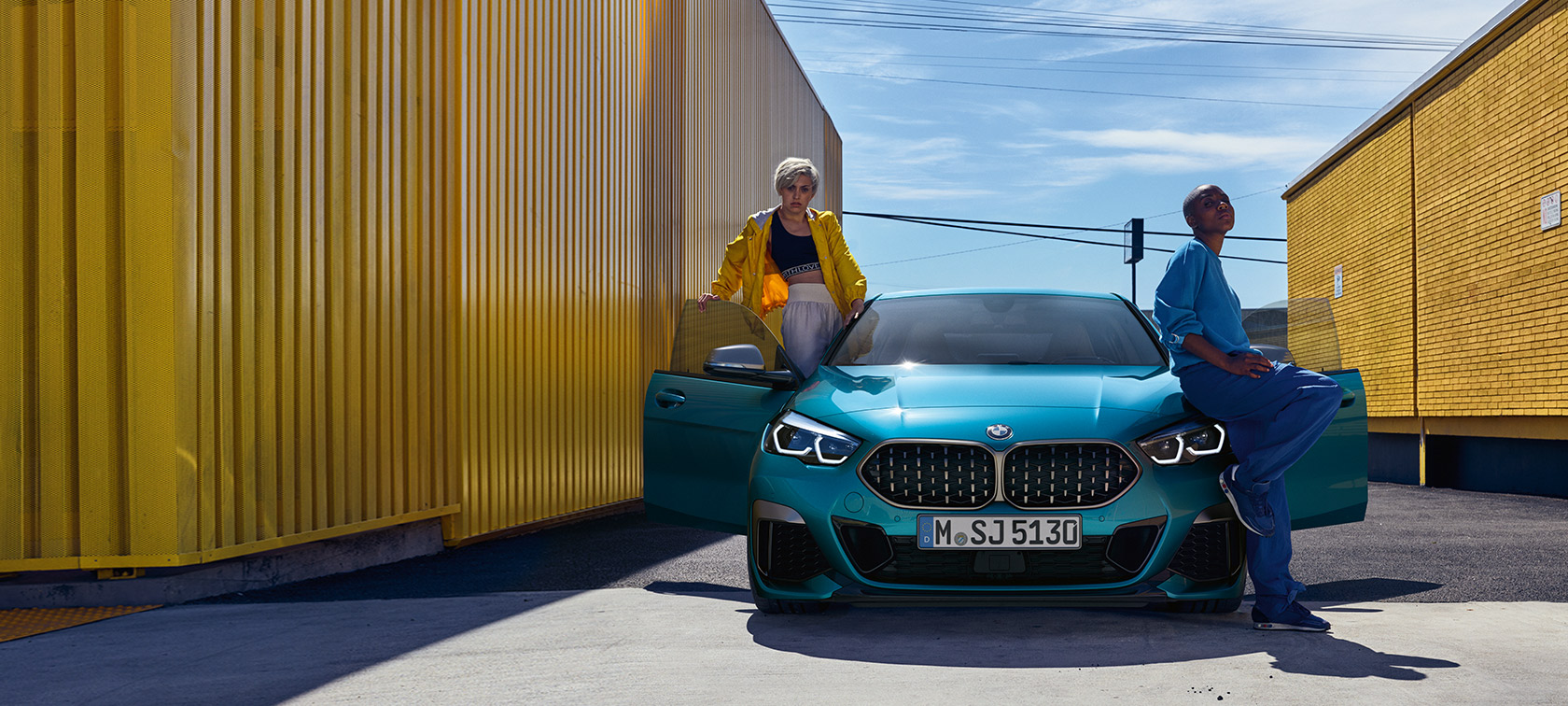 BMW Серија 2 Gran Coupé F44 Snapper Rocks Blue, поглед однапред до отворени врати и две лица во возилото